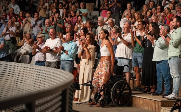 Imagen principal - Carolina Marín acudió al concierto en silla de ruedas; abajo, Arcángel cantando en solitario y junto a Jeromo Segura