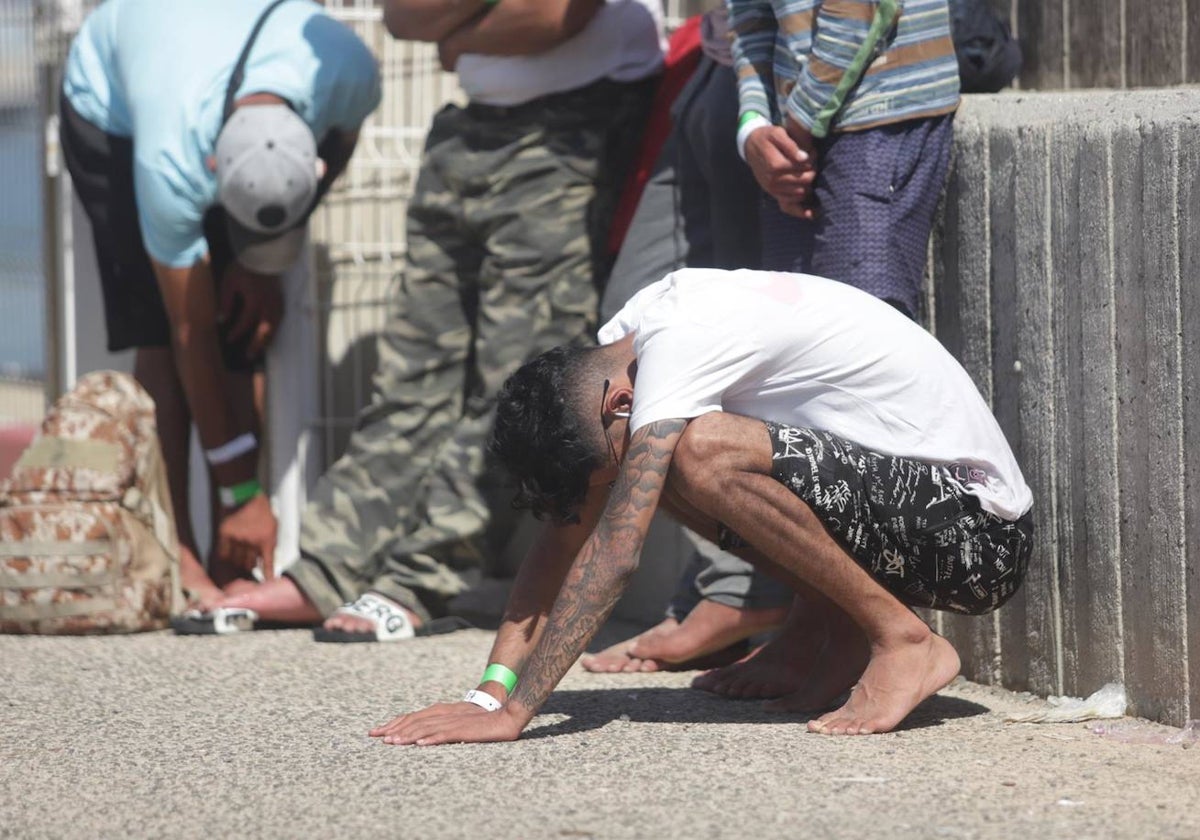 Un inmigrante rescatado se apoya en el suelo durante el rescate de 31 magrebíes, diez menores, de una patera en aguas de Barbate, a 23 de septiembre de 2022 en Cádiz