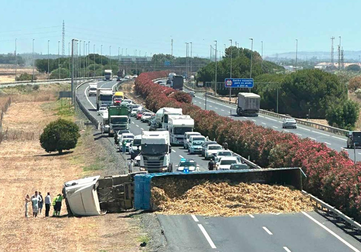 El remolque volcado con su carga en la calzada de la autovía