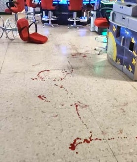 Imagen secundaria 2 - Arriba, La garrota usada en la pelea sobre el mostrador del salón de juegos. Sobre estas líneas, la policía atiende al herido y a la derecha el interior del local, donde se inició la reyerta