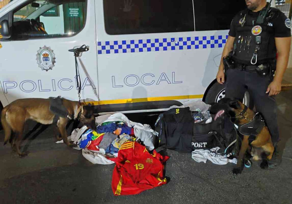 Un agente y sus perros con las camisetas requisadas