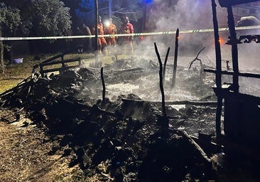 Bomberos junto a la chabola calcinada