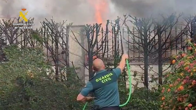 Agente de la Guardia Civil combate el fuego con una manguera