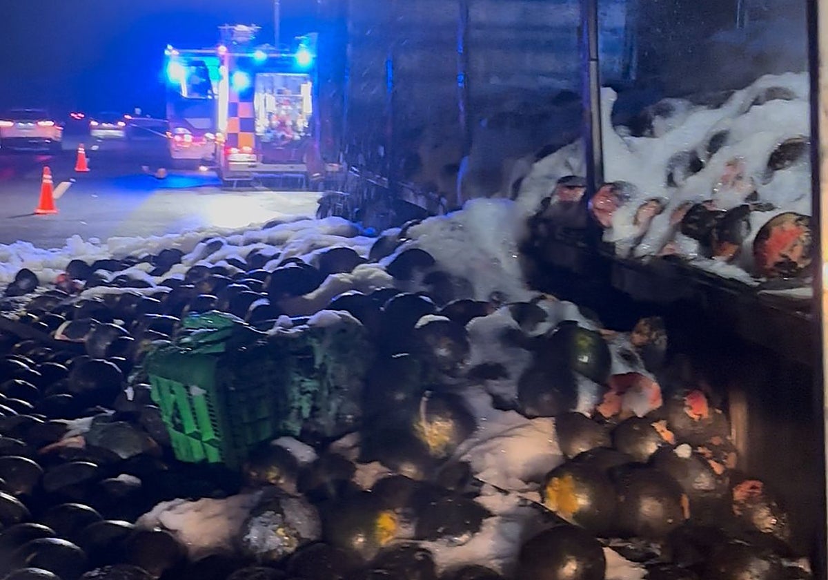 El camión calcinado, con toda la carga de sandías esparcidas por el asfalto