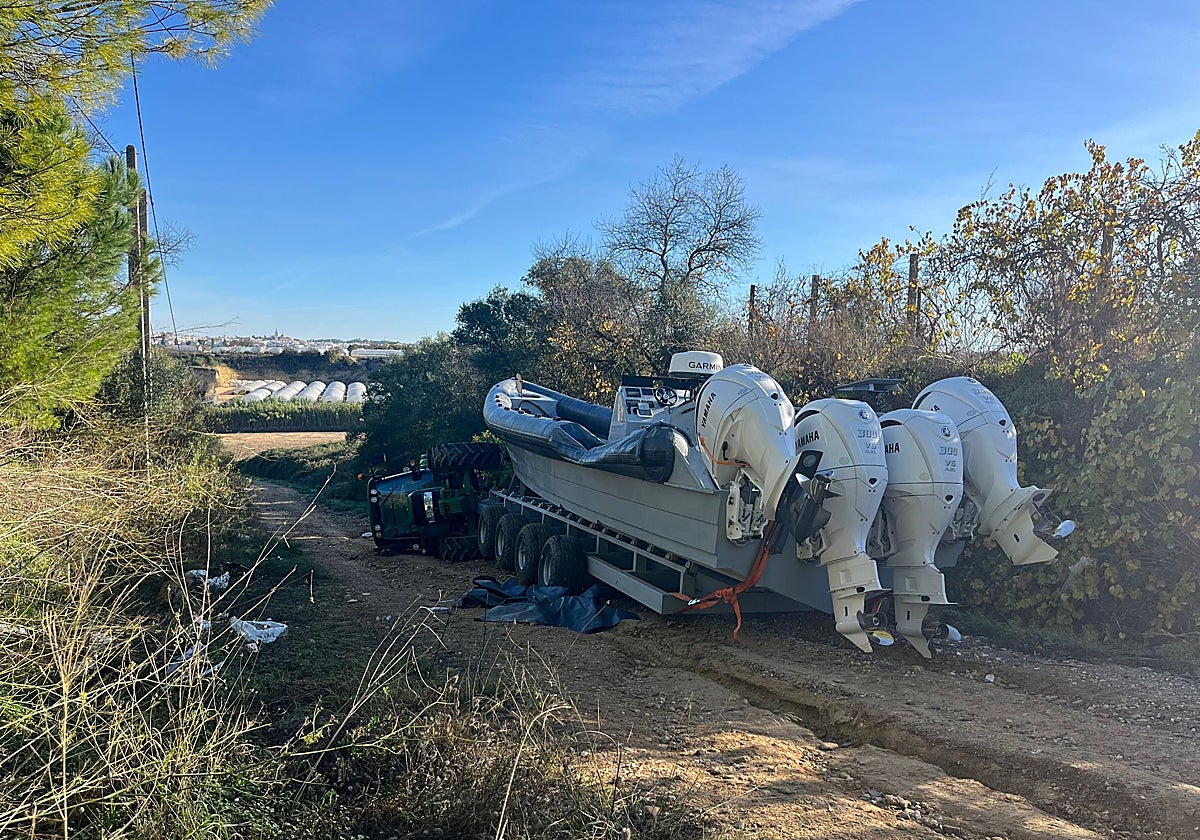 La narcolancha en el camino de Moguer y al fondo el tractor volcado