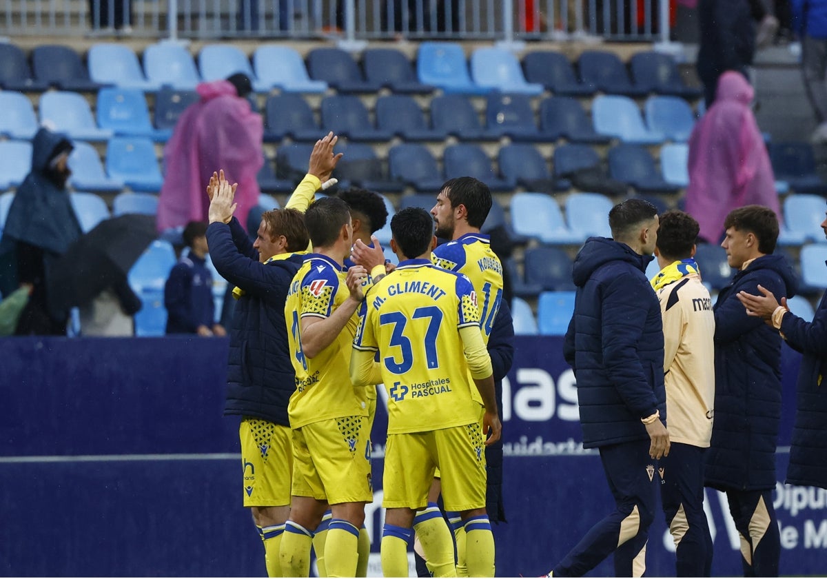 Los jugadores del Cádiz CF celebran el triunfo con la afición desplazada a Málaga