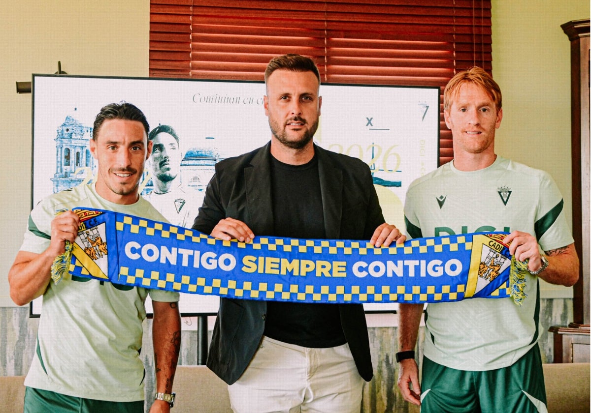 Iza Carcelén y Álex Fernández posan con una bufanda del Cádiz CF junto a Juan Cala