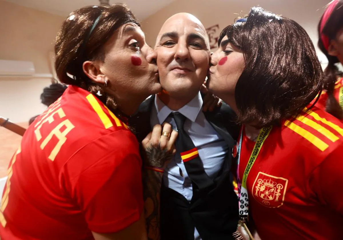 El doble de Luis Rubiales recibe dos besos de dos jugadoras de la selección femenina de fútbol.