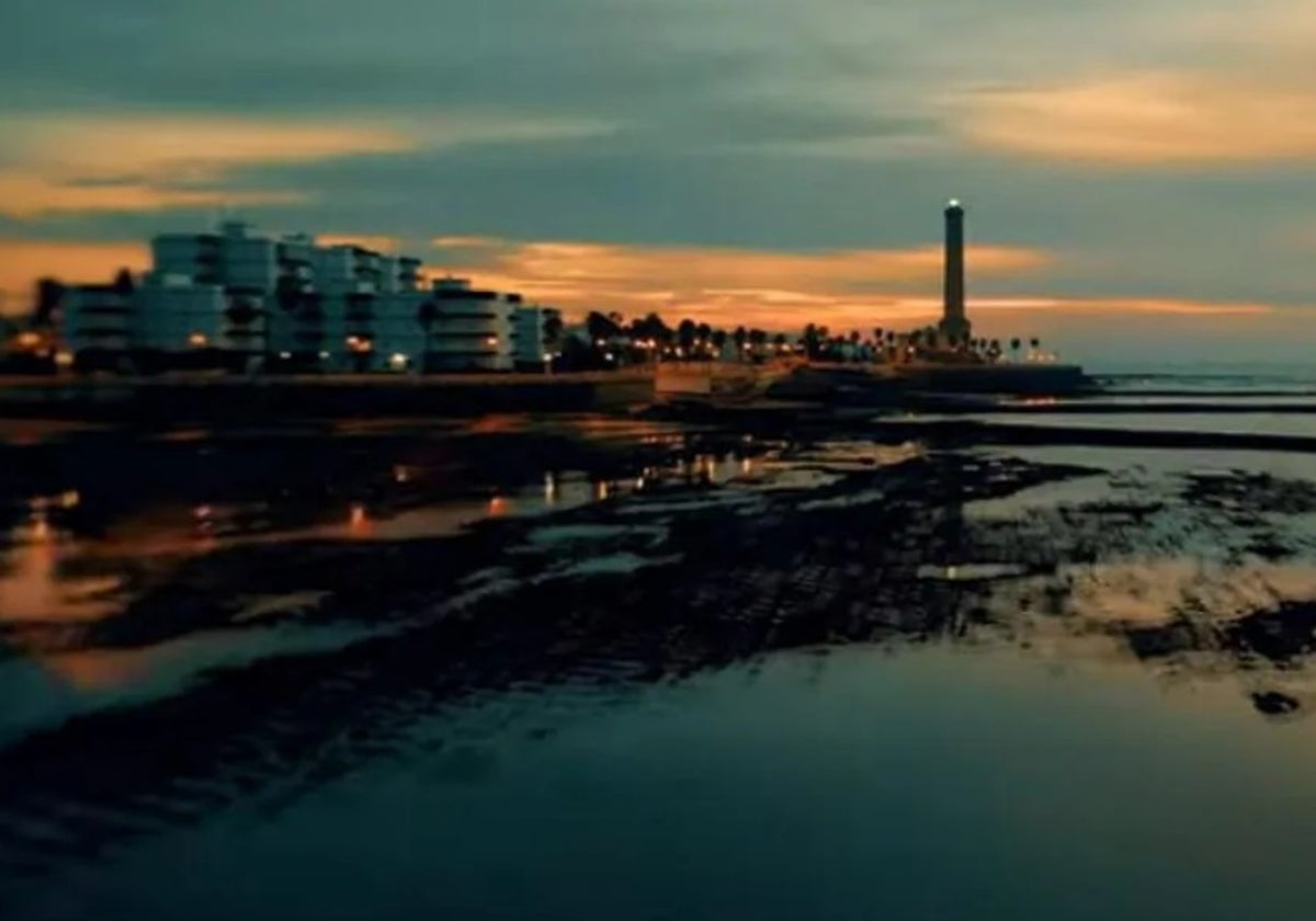 Atardecer en la playa de Chipiona con el faro al fondo