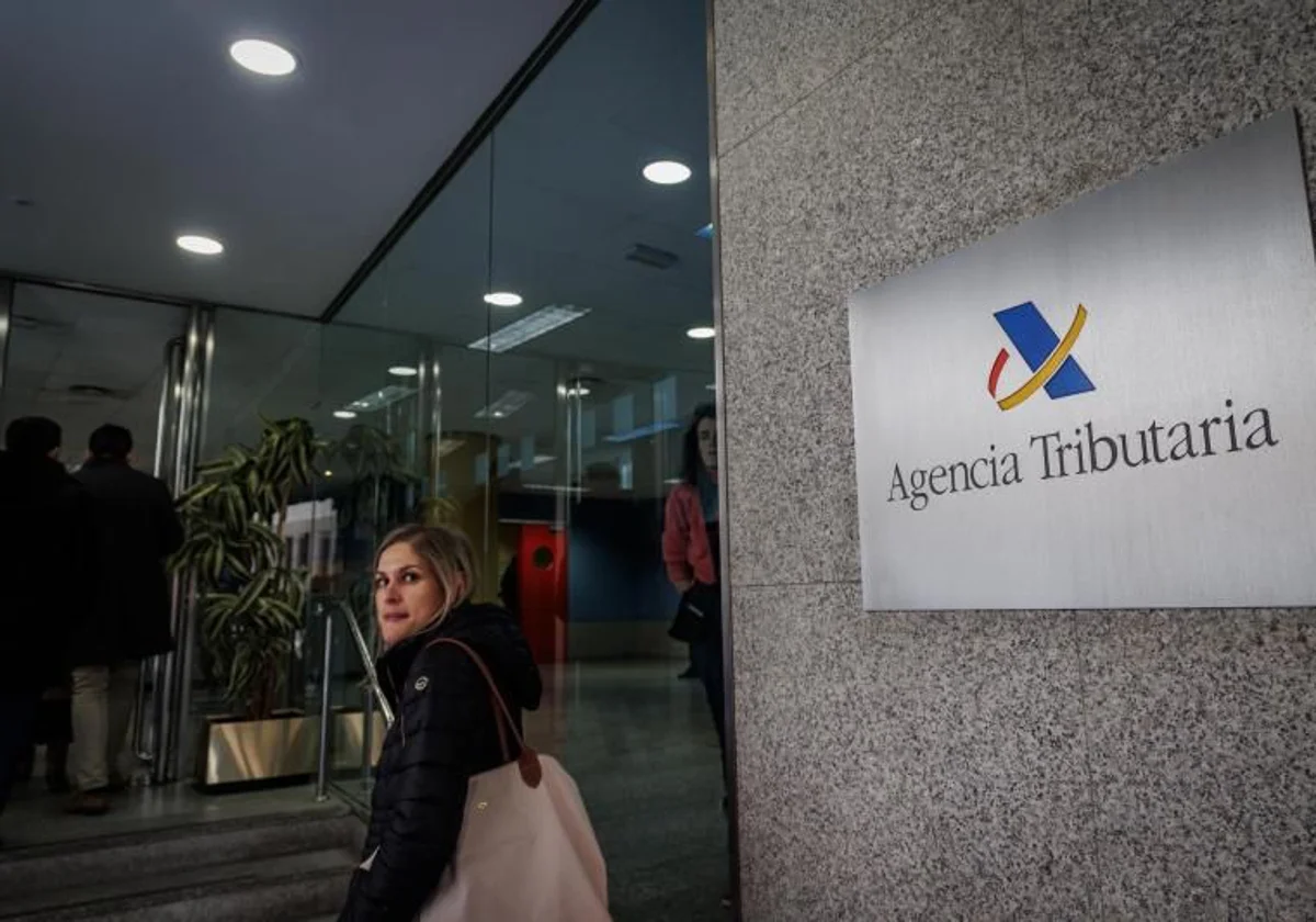 Foto de una mujer frente a la Agencia Tributaria