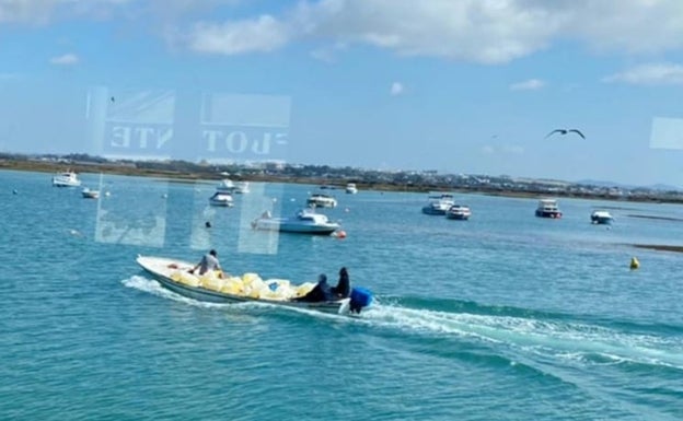 Una lancha sale hacia el exterior del caño Sancti Petri a darle el encuentro a una 'goma' después de haber cargado las petacas en el caño Chanarro.