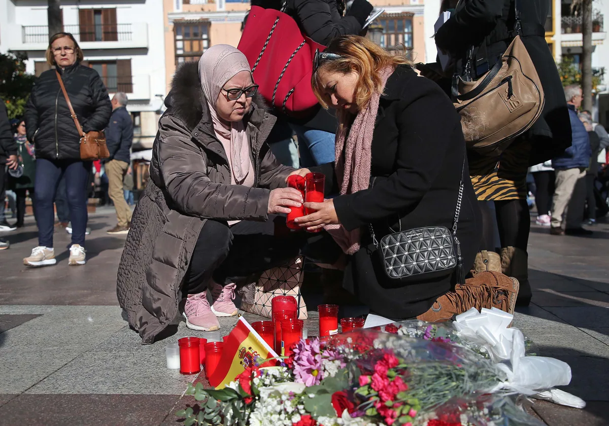 Vecinos depositan velas y flores como muestras de dolor en la Plaza Alta de Algeciras, donde caía el cuerpo sin vida de Diego Valencia.
