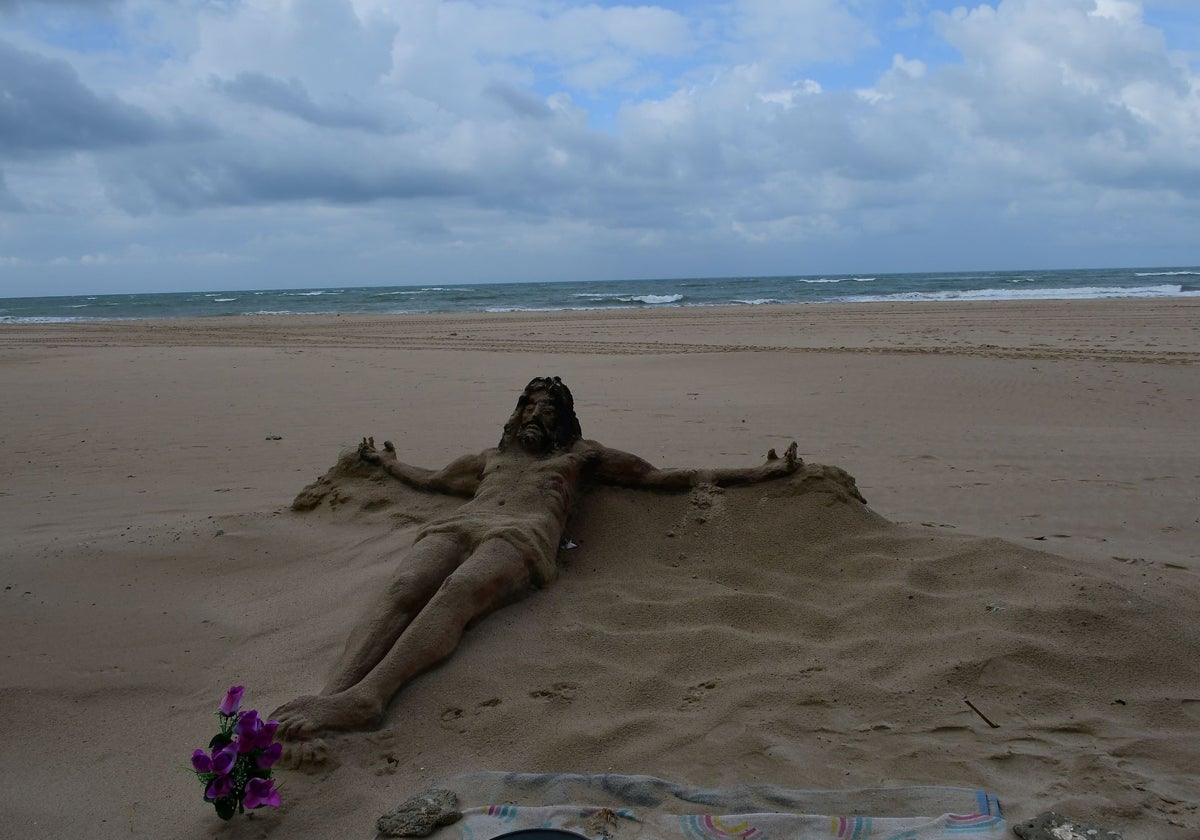 Una escultura y un ramo de flores, este lunes en la playa Victoria, en recuerdo de Carlos.