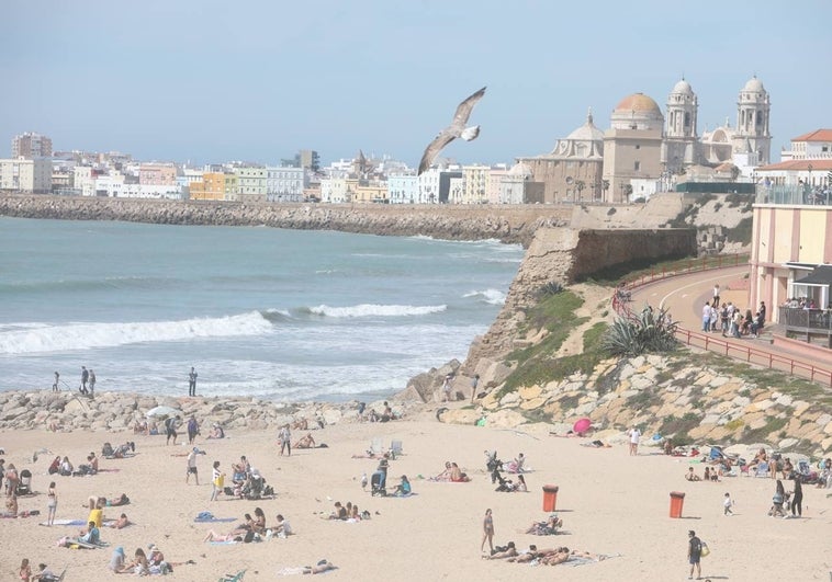 Surferos rescatan a una persona del agua en la playa de Santa María del Mar en Cádiz