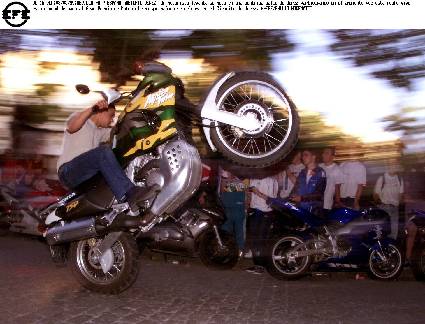Un motorista levanta su moto en una céntrica calle de Jerez participando en el ambiente del Gran Premio de Motociclismo.