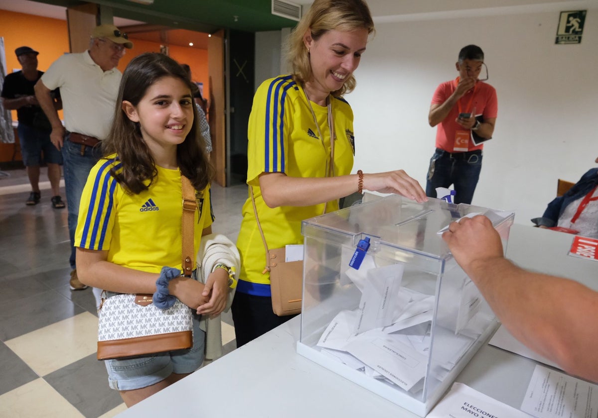 Una joven y su hija, acuden a las urnas con la camiseta del Cádiz CF.