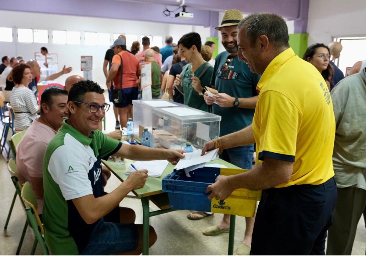 Un trabajador de Correos entrega una bandeja de votos.