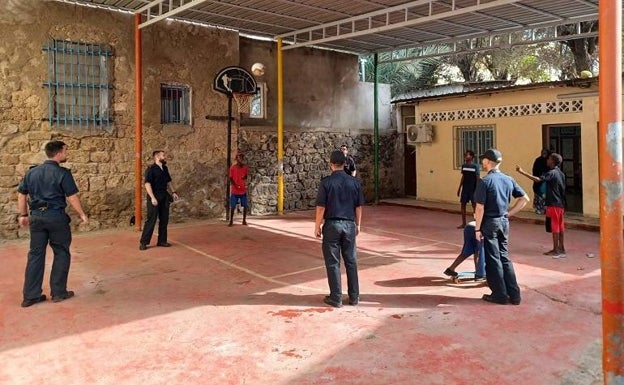 Varios miembros de la dotación del buque de la Armada española jugando al baloncesto con los niños del orfanato.