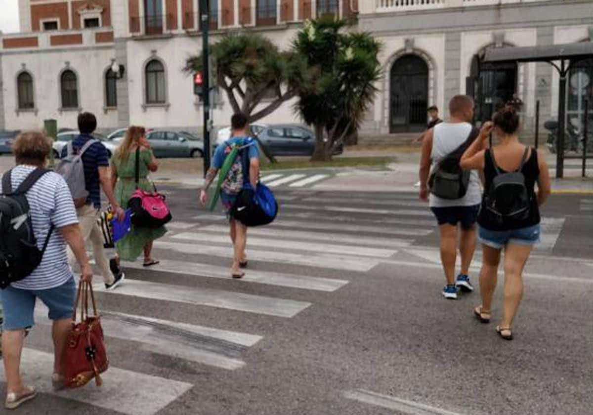 Viandantes cruzan por el paso de peatones de la Plaza Sevilla.