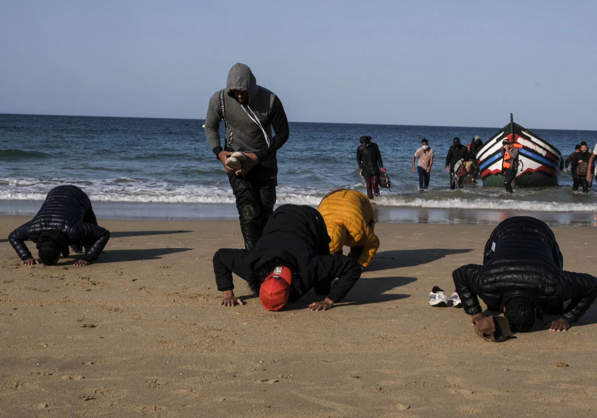 Imagen de unos inmigrantes al desembarcar de una patera llegada a la playa Victoria de Cádiz.
