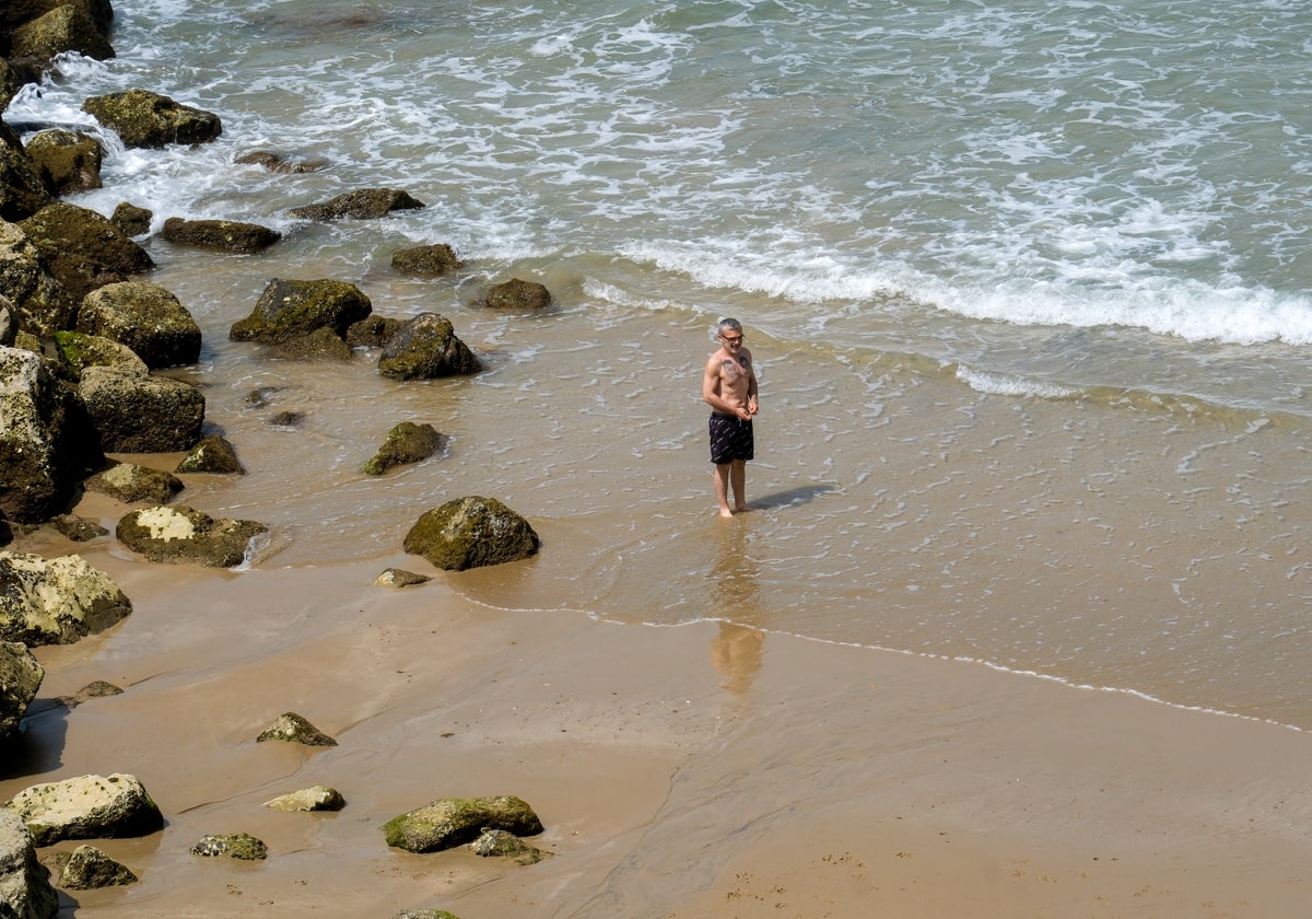 Un hombre, a punto de darse un baño en la playa