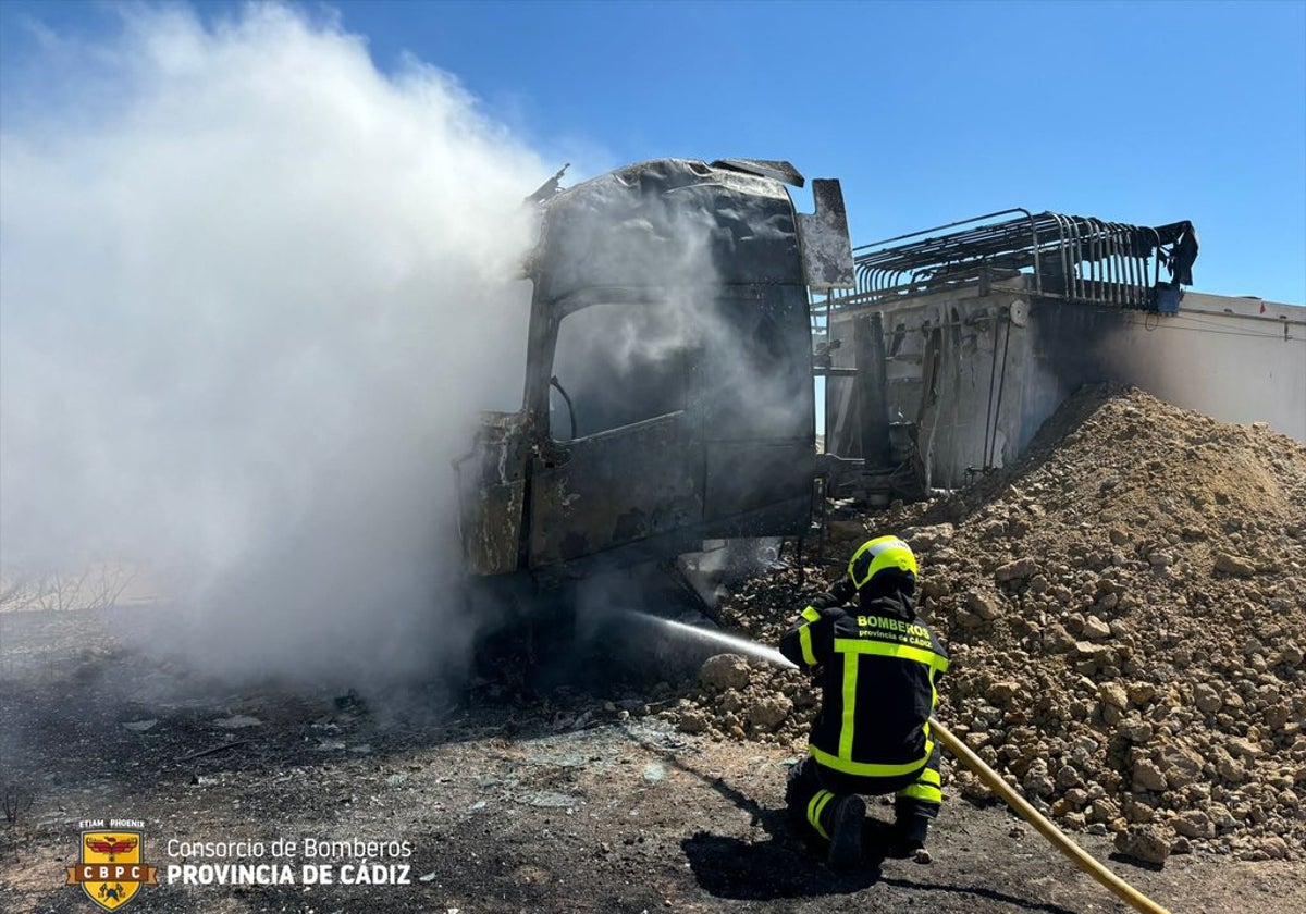 Un bombero trata de sofocar el fuego que afectó al tráiler