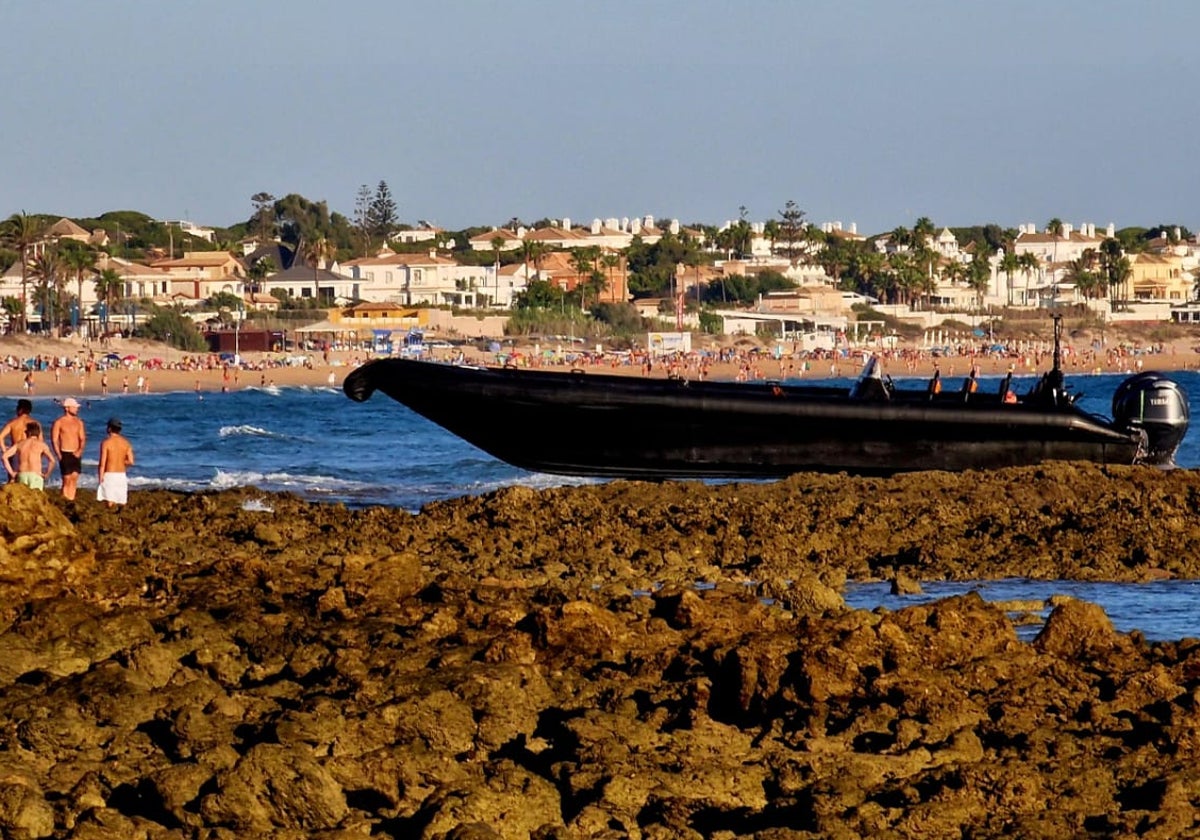 La narcolancha que ha llegado a Sancti Petri con quincena de inmigrantes encalló en las rocas.