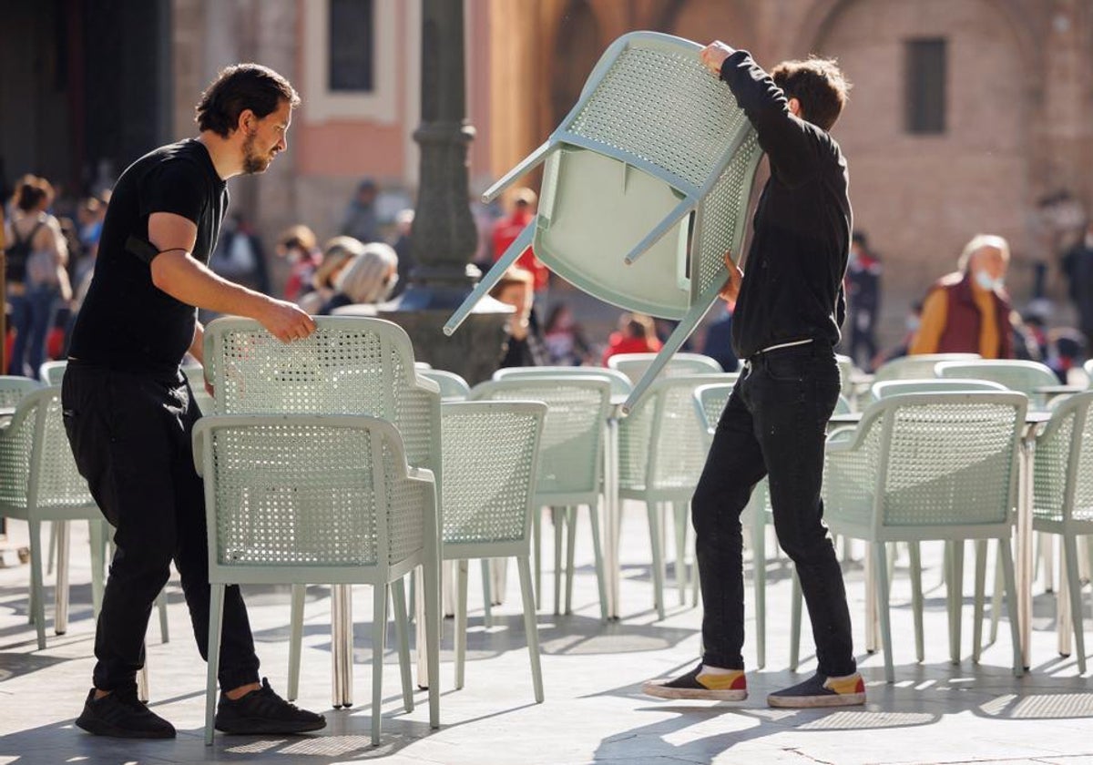 Dos camareros colocan una terraza en Cádiz