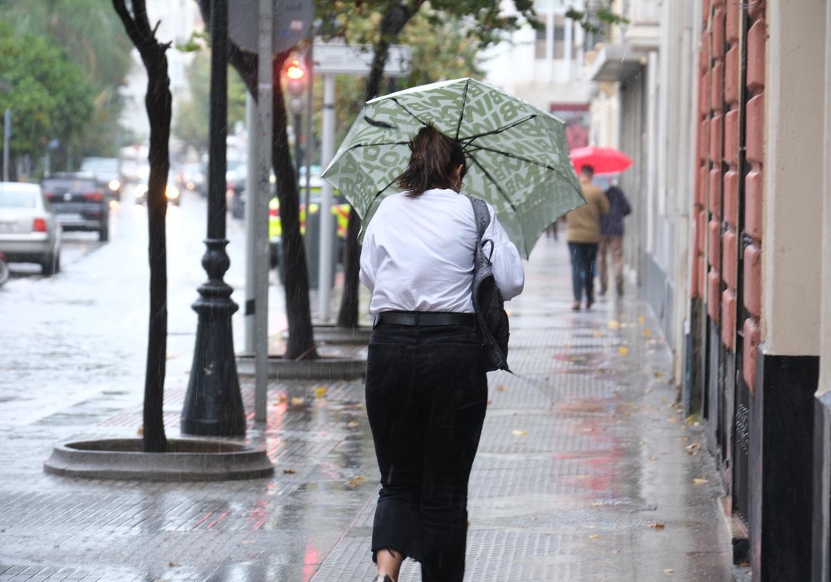 Una chica se protege de la lluvia en Cádiz con un paraguas