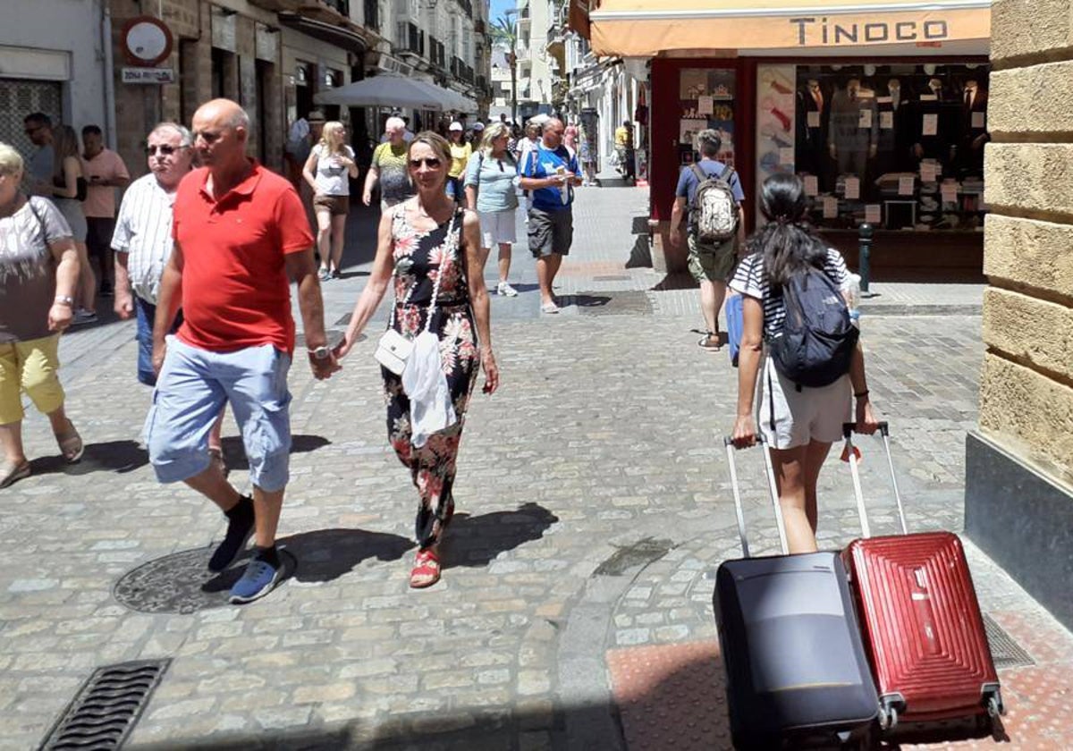 Una turista pasea por las calles de Cádiz capital, llenas de gente.