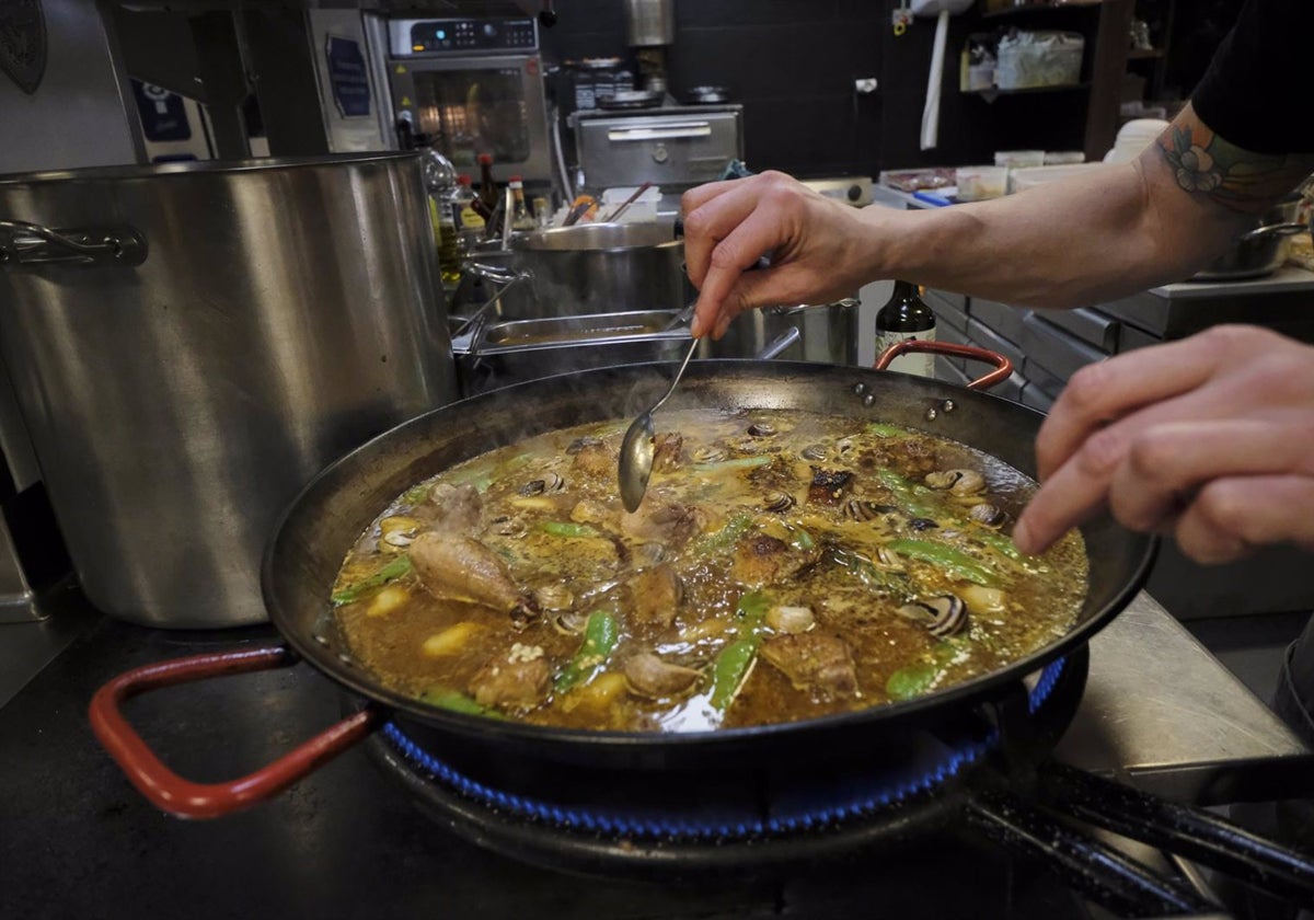 Un cocinero preparando un plato en los fogones de un restaurante.