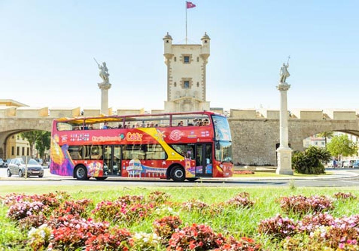 El autobús de City Sightseeing con la Puerta de Tierra de fondo