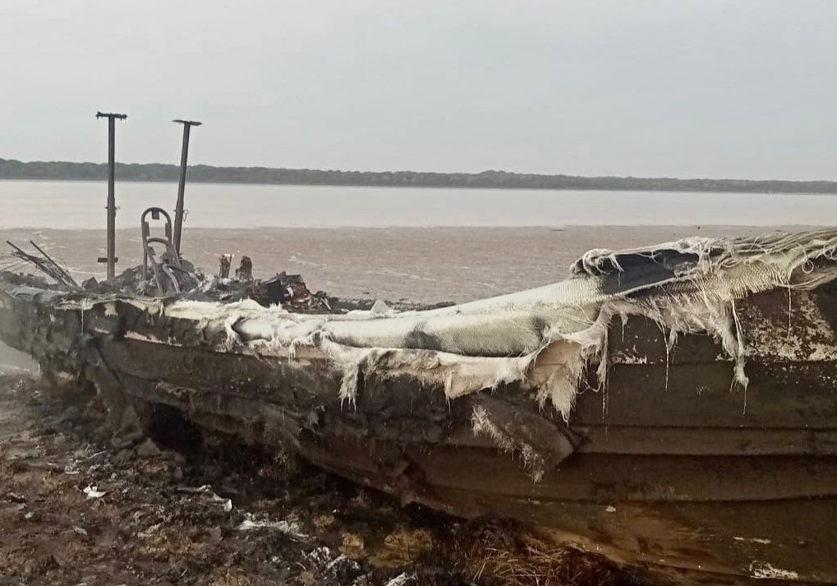 Una narcolancha quemada en la orilla de la desembocadura del Guadalquivir.