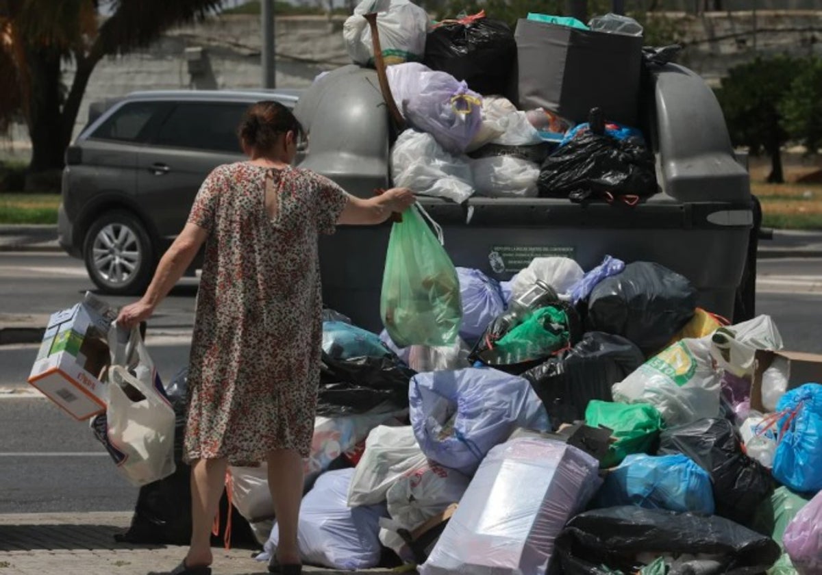 Una mujer tira la basura en Sanlúcar.