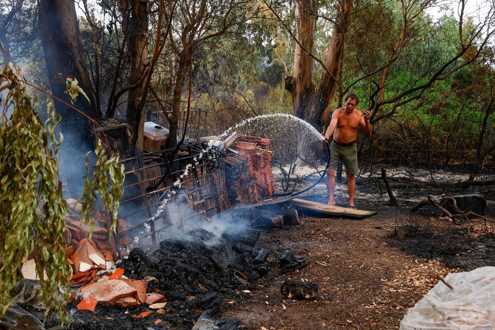Una persona intenta apagar unas llamas en el incendio del paraje La Peña