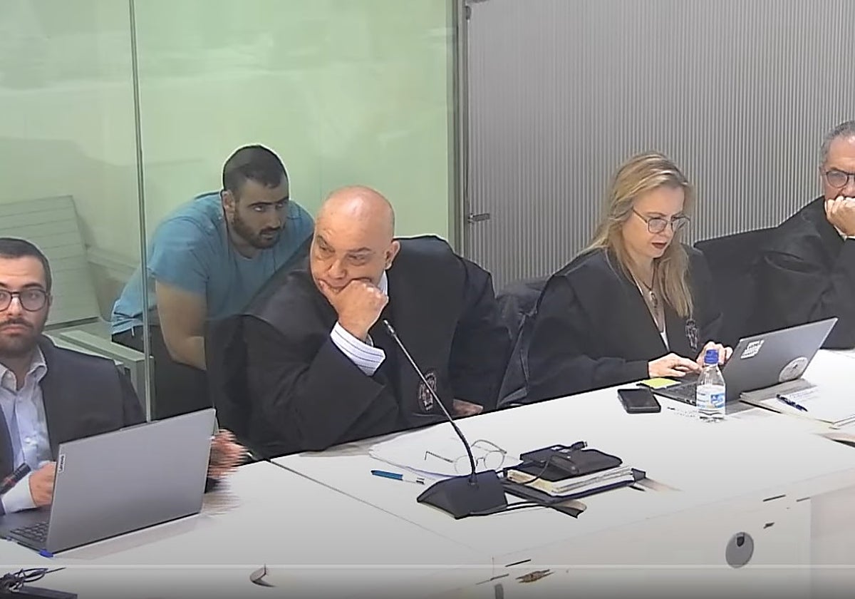 Yassine Kanja, en segundo plano, asiste al juicio en la Audiencia Nacional tras una mampara de cristal