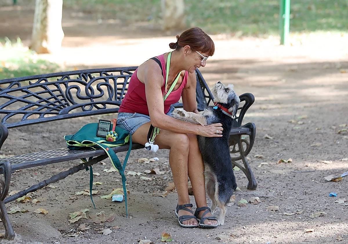 Una mujer juega con su perro en un parque