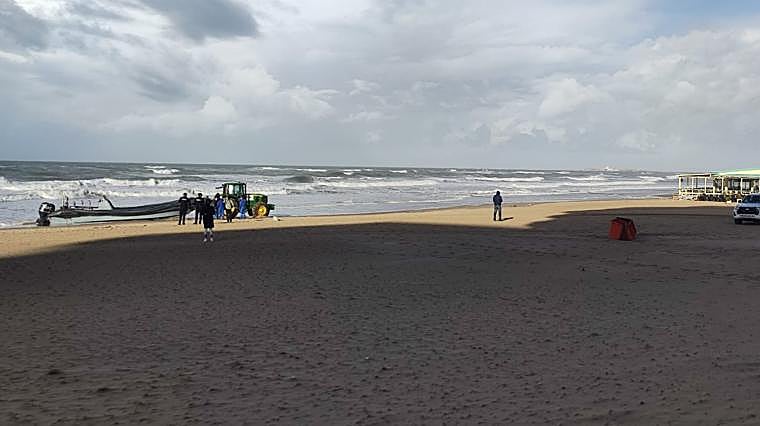 Numerosos transeúntes se han acercado para ver la embarcación, embarrancada muy cerca de los chiringuitos