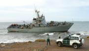 Agentes de la Guardia Civil observan la patrullera de la Armada «P.22 Tagomago», encallada en la playa de Las Coloradas. EFE