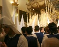 Nazarenos de Los Negritos ante el paso de la Virgen de los Ángeles tras decidir la junta de gobierno no hacer estación de penitencia a causa de la fuerte lluvia. PEPE ORTEGA