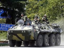 Un soldado ruso conversa con un vecino de Gori, en Georgia. /EFE