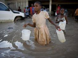Dos niñas buscan un surtidor de agua potable en Gonaives, Haití. /AP