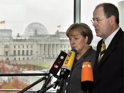 La canciller alemana Angela Merkel (i), junto al ministro de Finanzas, Peer Steinbrueck, durante su comparecencia ante los periodistas tras la reunión de crisis celebrada. /EFE