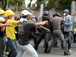 Un grupo de Policías cargan contra los manifestantes a las puertas del Parlamento tailandés./ AGENCIAS