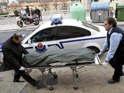 Dos hombres trasladan el cadáver de la mujer que ha fallecido en su domicilio de la localidad guipuzcoana de Errenteria tras ser apuñalada presuntamente por su pareja. / Efe