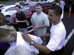Obama le firma una camiseta a una 'fan', durante sus últimas vacaciones en Hawai. / Afp