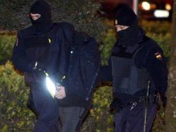 Dos agentes trasladan a uno de los ocho detenidos en Hernani. / Efe