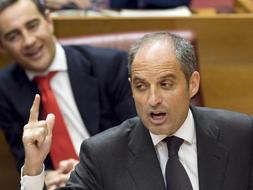 El presidente de la Generalitat, Francisco Camps, en presencia del portavoz del grupo popular, Ricardo Costa (detrás), durante el pleno de Les Corts Valencianes. / Efe