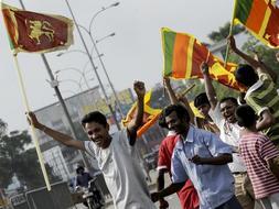 Ciudadanos de Sri Lanka ondean la bandera nacional para celebrar la victoria del Ejército frente a la guerrilla tamil. / Afp