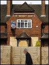 Un hombre camina frente a un pub cerrado en Chessington, un barrio al sur de Londres / REUTERS